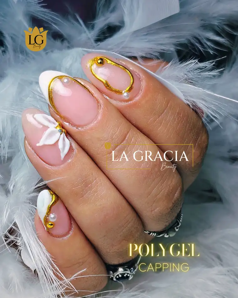 Capping de Polygel nude con una flor blanca y líneas doradas, trabajo de La Gracia Beauty