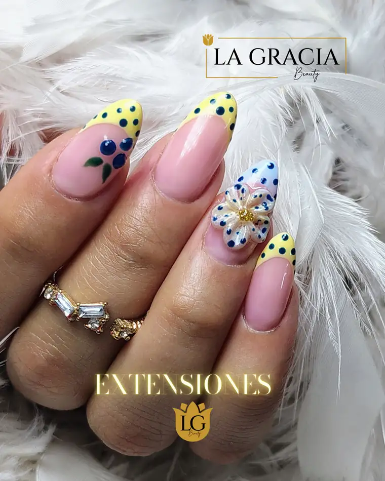 Extensiones en tonos pastel con lunares negros y mariposas amarillas, trabajo de La Gracia Beauty